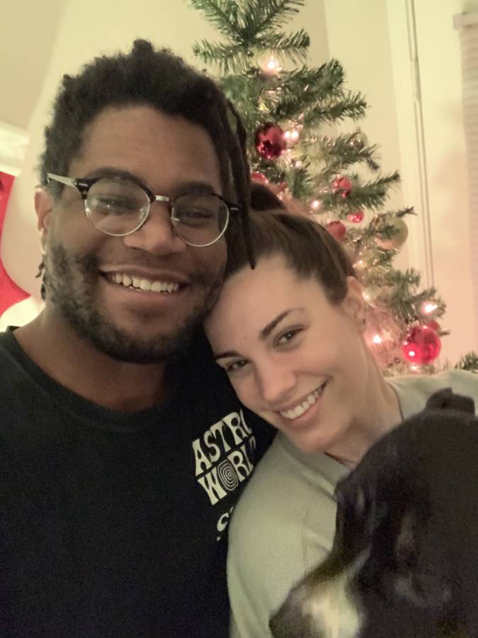 Hailey and Tristan smiling in front of a Christmas tree