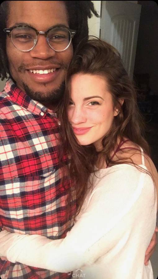 An early selfie of Tristan in a red plaid shirt and Hailey hugging him close, both grinning